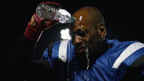 A football player drinking water and pouring it on his head วิดีโอสต็อก