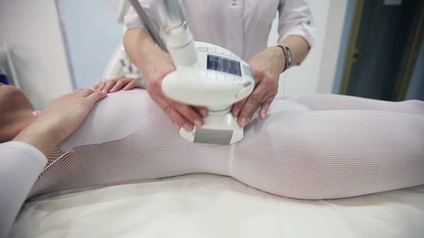 Health and beauty: Woman in specific tights is massaged for reducing cellulite with electronic massage system