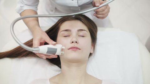Health and beauty: Woman is massaged for reducing face with electronic massage system