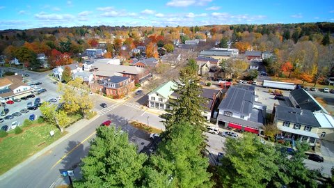 Small town forward 4k aerial, looking at daily life in upstate NY village, Millbrook.in the fall.