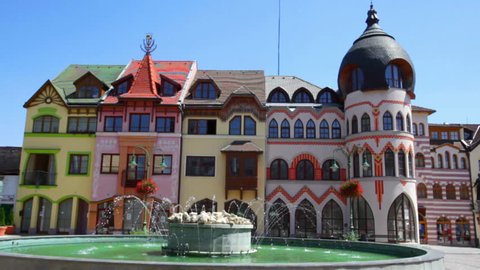 KOMARNO, SLOVAKIA - JULY 24, 2013: Summer view of Komarno town centre and playing fountain on Europe Square in front of bright buildings.