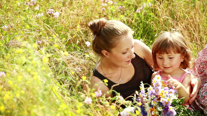 Mother and baby in the flowers. They laugh. 