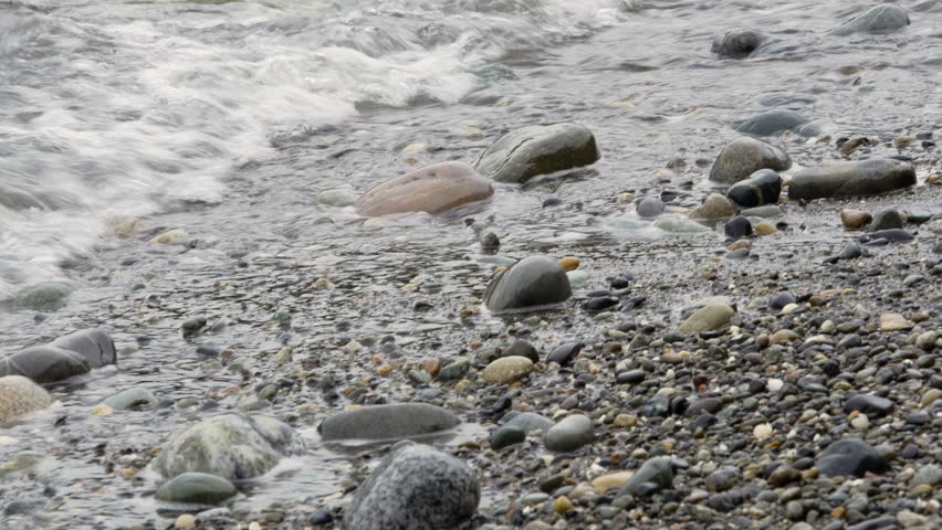 Close up of gentle waves lapping on beach pebbles at Deception Pass State Park, Washington State.