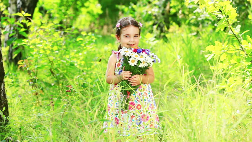 Girl with a bouquet of wild flowers in the grass 