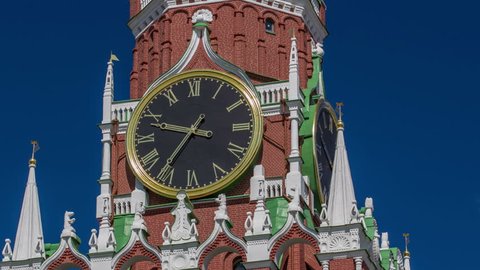 Moscow Kremlin, Red Square. Spasskaya Savior's clock tower timelapse hyperlapse decorated by the red ruby star on the top of it. Blue sky background. UNESCO World Heritage Site.