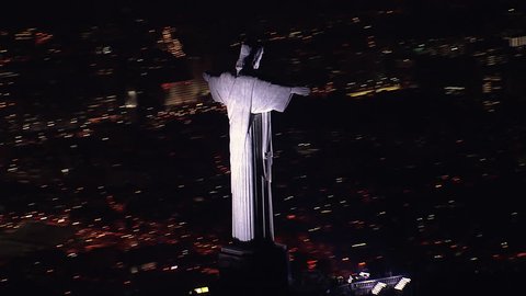 RIO DE JANEIRO, BRAZIL - OCTOBER 2015: Aerial closeup view of illuminated Christ the Redeemer Statue at Night, Rio de Janeiro, Brazil. View of Christ overlooking Rio with background city lights.