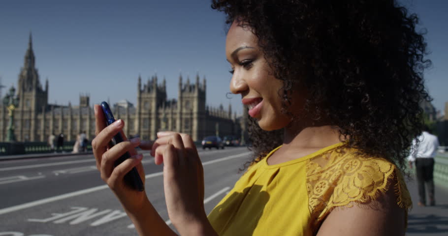 A young African American businesswoman talking on her smartphone. Shot on RED Epic.