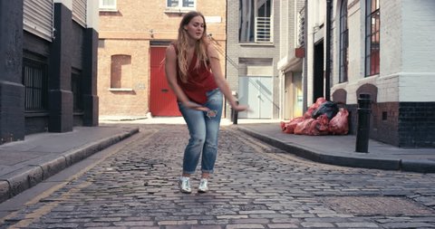 Contemporary street dancer woman happy funky urban dancing freestyle in the city
