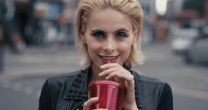 Slow Motion Portrait of happy beautiful caucasian punk woman drinking juice in city real people series