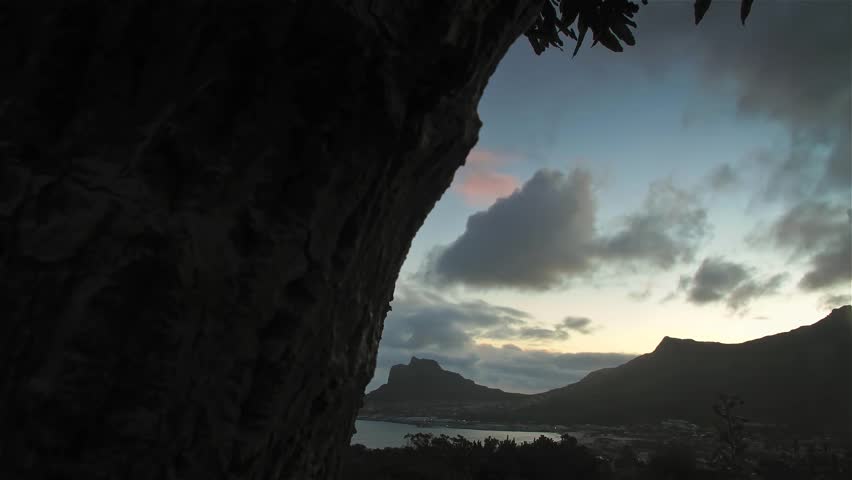 Tracking time lapse of clouds rolling over bay at sunset