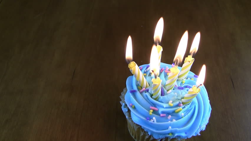 HD of six birthday lit candles on a cupcake