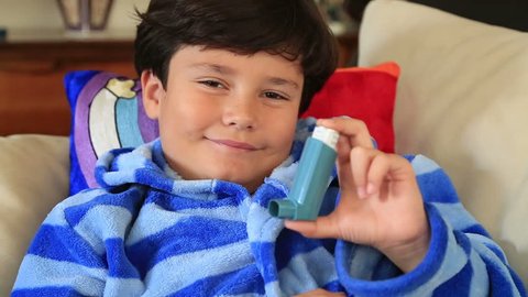 Little boy showing his inhaler