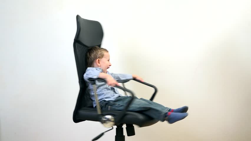 Fuuny kid spinning in an office chair, manager has fun at work Royalty-Free Stock Footage #12674699
