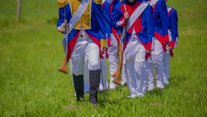 The soldiers in Napoleon army marching into historical battle in a beautiful nature on countryside.