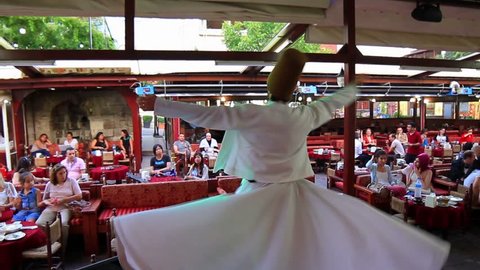 ISTANBUL - JUL 15, 2013: Semazen conveys Gods spiritual gift to those are witnessing the ritual. An unidentified whirling dervish spins with the islamic chant music. Sufi whirling dervish (Semazen) 