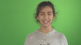 Young Girl Laugh - A young girl laughs isolated on a green screen studio background