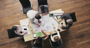 Top View of Business people meeting around boardroom table discussing architectural plans for new sustainable shared office space - Powered by Shutterstock - Get 15% off with code: PIKWIZARD15