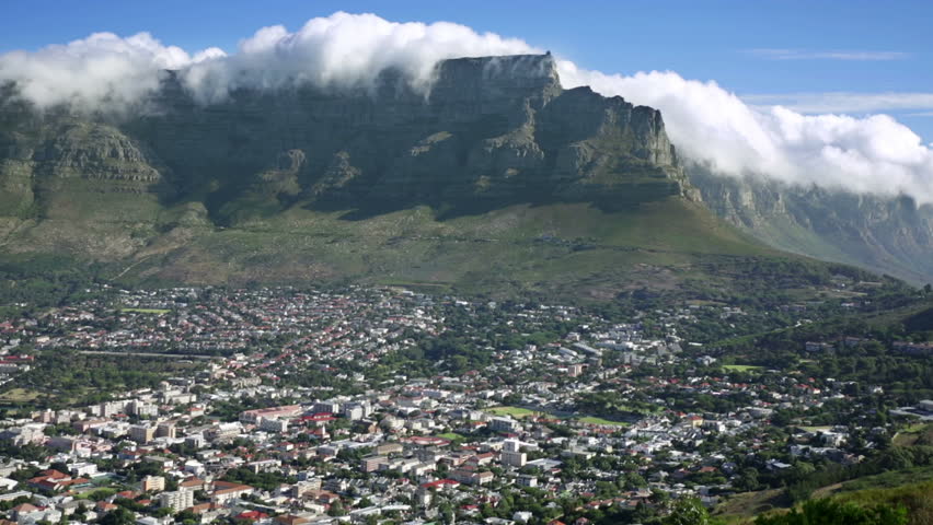  Table Mountain view from Signal hill road, classic beautiful scene of the "table cloth" cloud layer rolling off the flat top & the shadowed steep slopes with green fauna meeting the city bowl suburbs