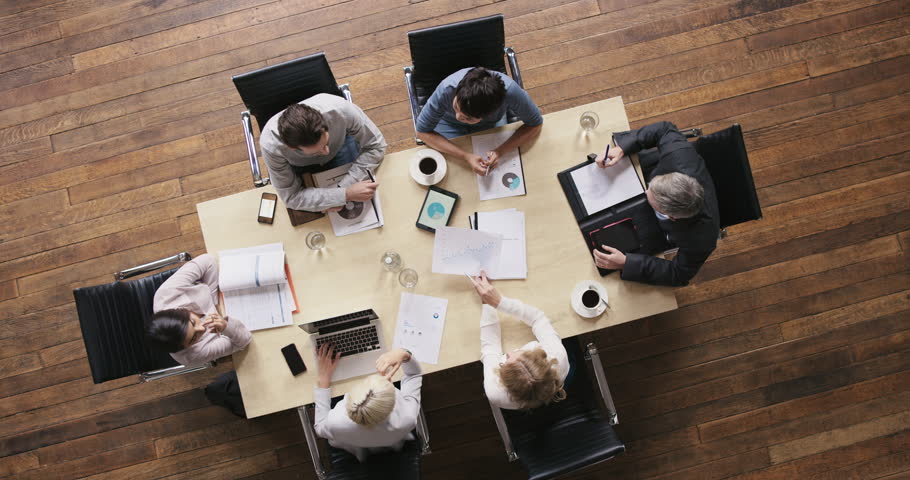 Top view diverse business people meeting at boardroom table discussing financial report using graphs and big data in trendy shared office space Royalty-Free Stock Footage #12707153