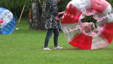 VILNIUS, LITHUANIA - MAY 23: children with parents recreate in park with zorb bubbles balls on May 23, 2015 in Vilnius, Lithuania. Zoom out shot. 4K