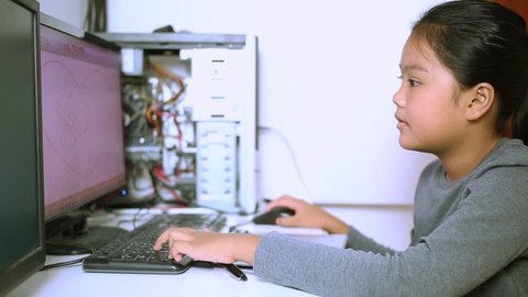 Asian teen using computer for doing home work at home