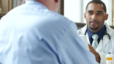 Doctor discussing prescription drugs with male patient, videoclip de stoc