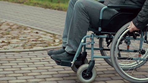 Disabled man using wheelchair on path