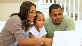Happy young african-american family using wireless technology to talk to relatives
