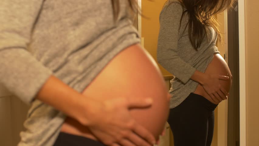 woman behind turns reveal pregnant belly: Stockvideók (100%-ban jogdíjmente...