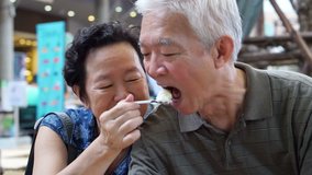 Asian senior elder couple eating an ice cream and feed each other abstract eternal love - Powered by Shutterstock - Get 15% off with code: PIKWIZARD15