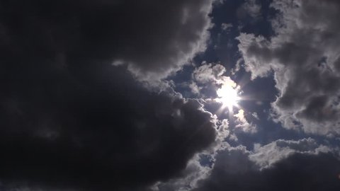 sun behind black cloud 