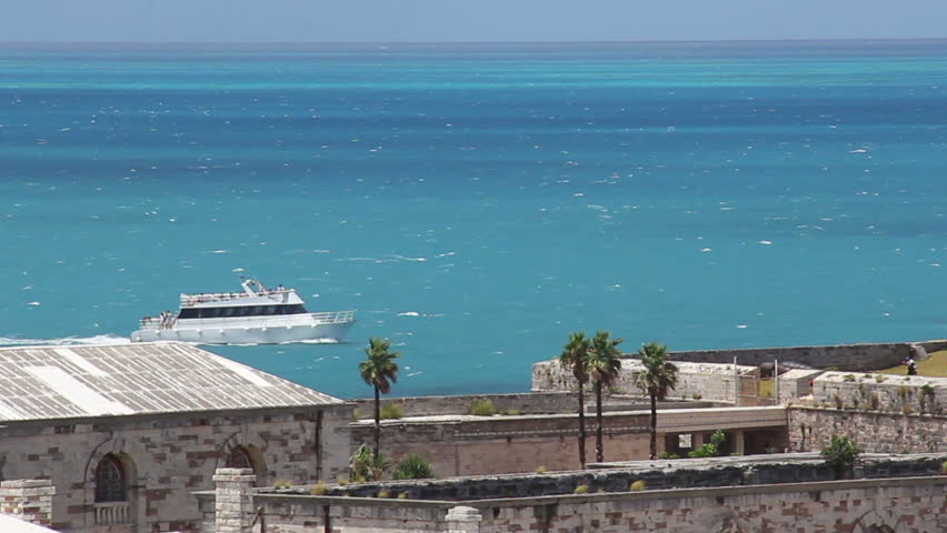 A tour boat travels near the coastline of the island of Bermuda in the Atlantic