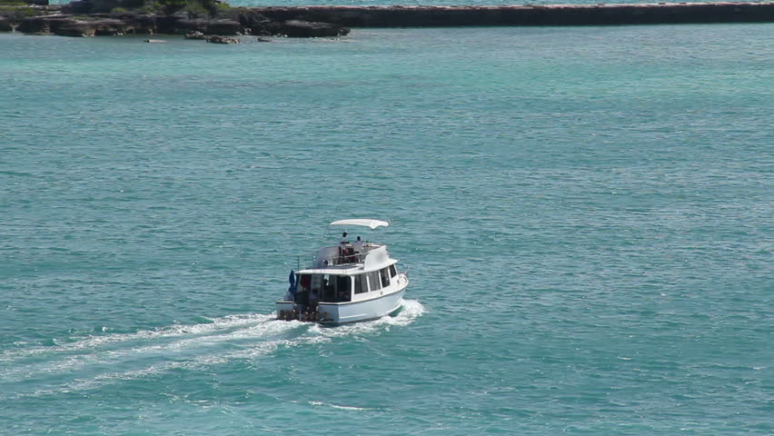 A pleasure tour boat travels near the coastline of the island of Bermuda in the