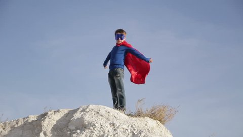 superhero boy  runs through the mountains and trying to fly