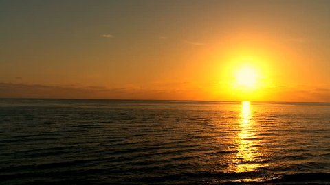 Tranquil scenic view of golden sunset over gentle ocean waves