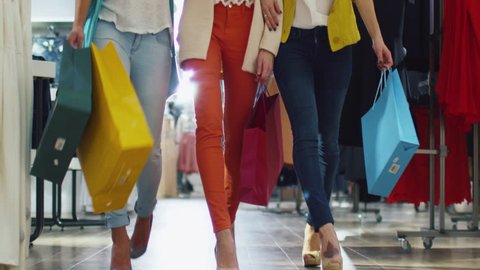 Low shot of female legs walking through a department store in colorful garments. Shot on RED Cinema Camera in 4K (UHD).