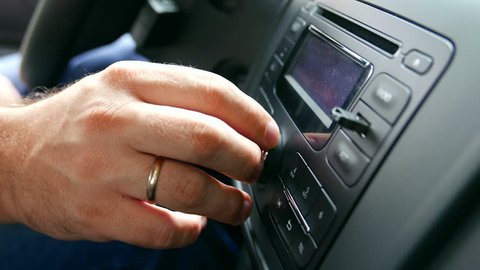 Audio, radio music in the car. Driver switches and listens the radiostations or music tracks