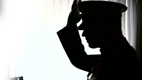 Silhouette of Marine putting on his hat.
