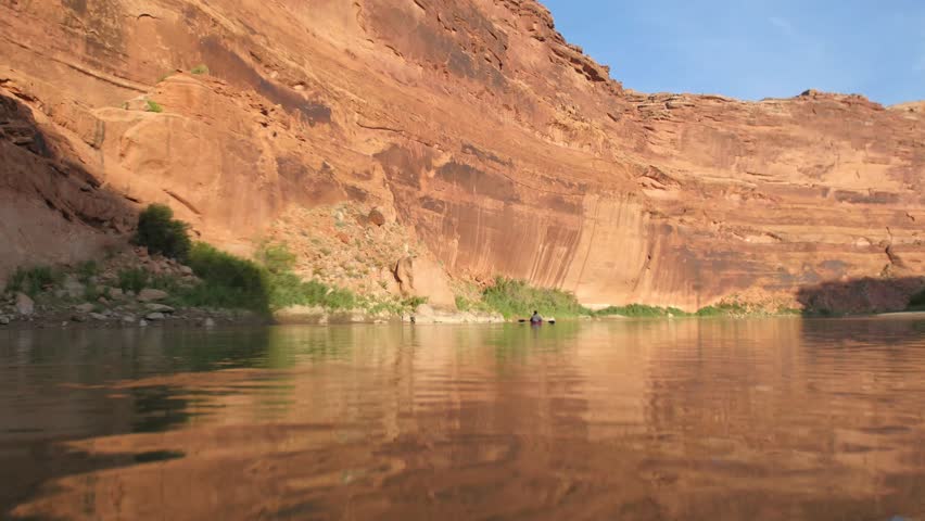 Kayaker with red cliffs on side