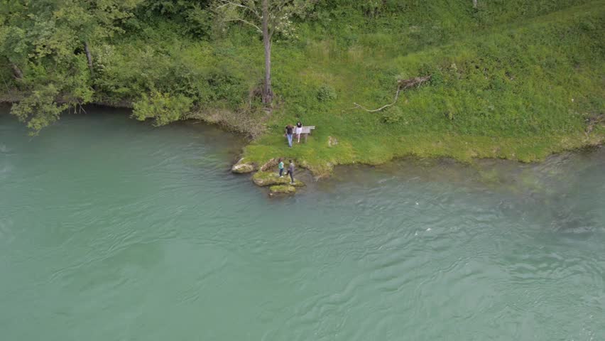 Four young people enjoying on the small river - aerial view from small drone.
