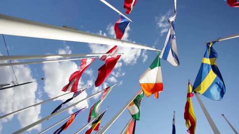 Many bright flags waving at blue sky background