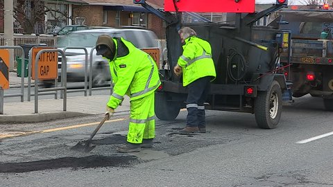 Toronto, Ontario, Canada March 2014 City workers patch and fill potholes on city roads and streets after a long cold severe winter
