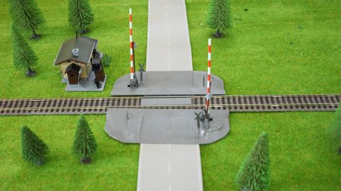 Model railway crossing: the car is moving and moving train it knocks. Stop motion.