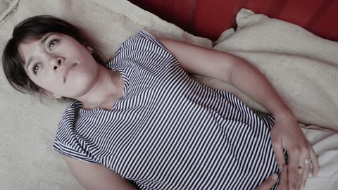 Hispanic woman lying down on bed relaxing. 4k