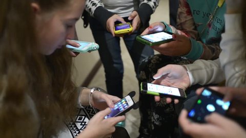 KHERSON, UKRAINE - NOVEMBER 14, 2015: Children with their Smartphones and mobile phone in school