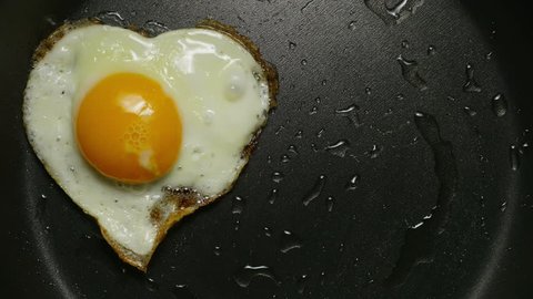 Couple eggs in frying pan. Form of heart. Cooking fried eggs in the form of heart. ?lose-up 4K UHD.

