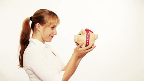 Happy young woman kissing a piggy bank