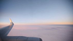 Purple clouds seen through the window of jet airplane at the sunrise. HD video (High Definition).