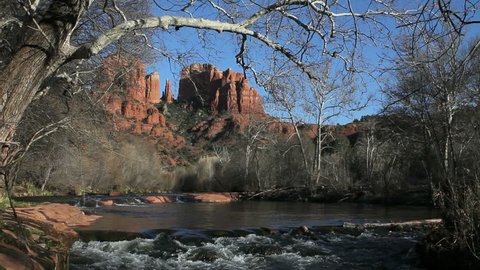 Beautiful scenic of tree hanging over bubbling Oak Creek with Cathedral Rock in background, Sedona, Arizona. 1080p