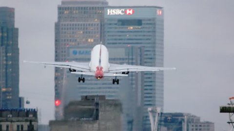 London City Airport, November 2015. London is facing fierce competition as Europe's financial centre, in this video A commercial aircraft takes off against a background of corporate skyscrapers, 